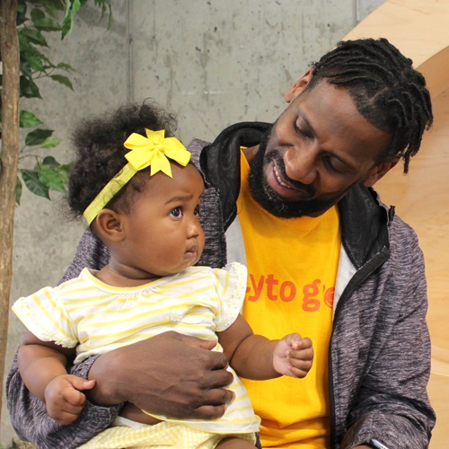 Black man holding infant daughter
